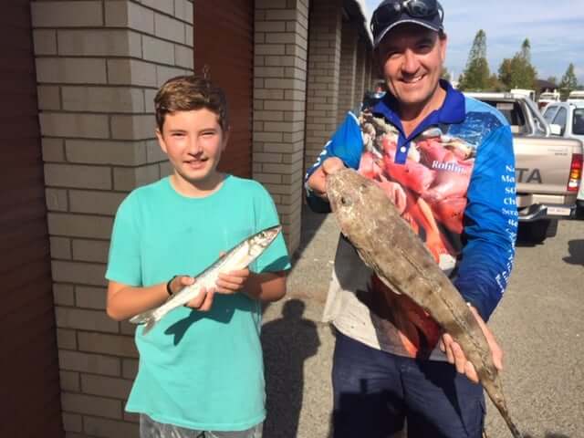 A man and a boy holding fish