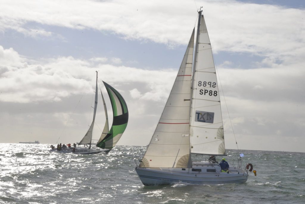 Two yacht sailing in choppy conditions, one yacht has green spinnaker